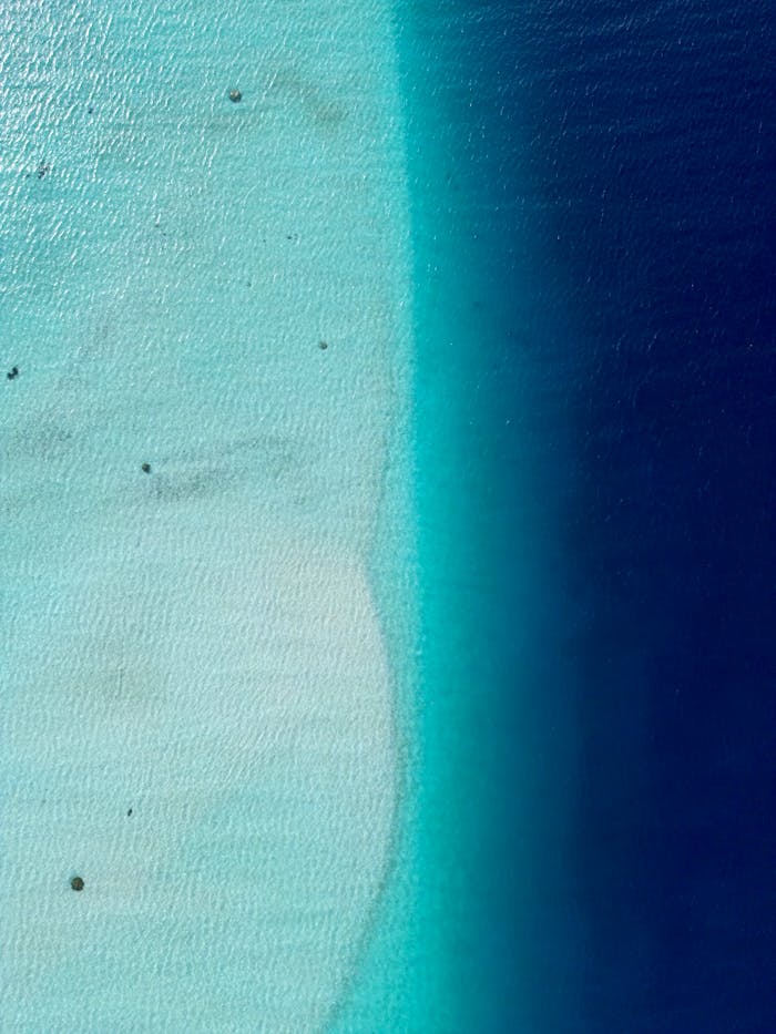 Stunning aerial view of Huahine's lagoon in Polynesia, showcasing vibrant blue shades.